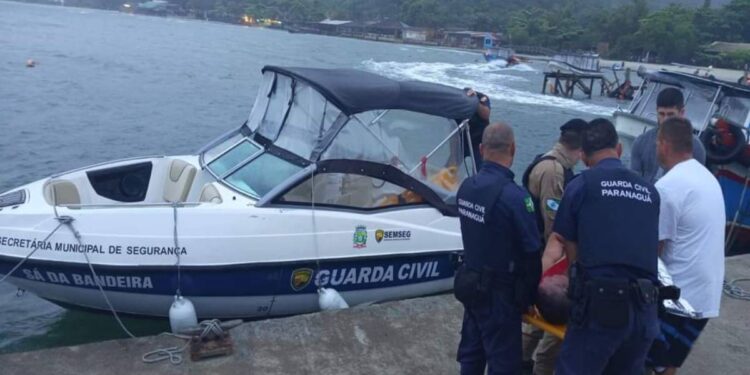 Policiais militares, guardas civis municipais e voluntários prestam atendimento à turista que caiu das pedras na Ilha do Mel