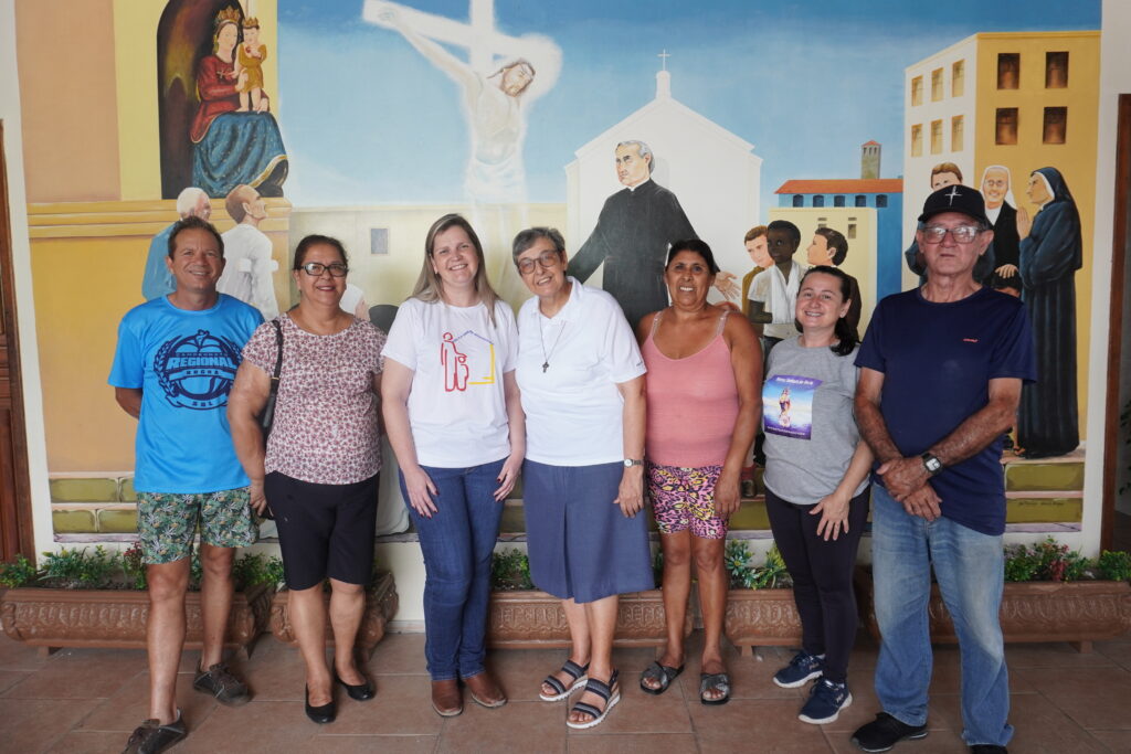 No centro da imagem estão a coordenadora do projeto Amor ao Próximo e a diretora do Instituto Palazzolo, cercadas por alguns dos voluntários que apoiam as ações da instituição - Foto: Guilherme Prebianca/Ilha do Mel FM